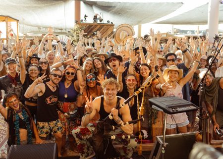 Crowd gathered at Joshua Tree Music Festival under bright desert festival structures.